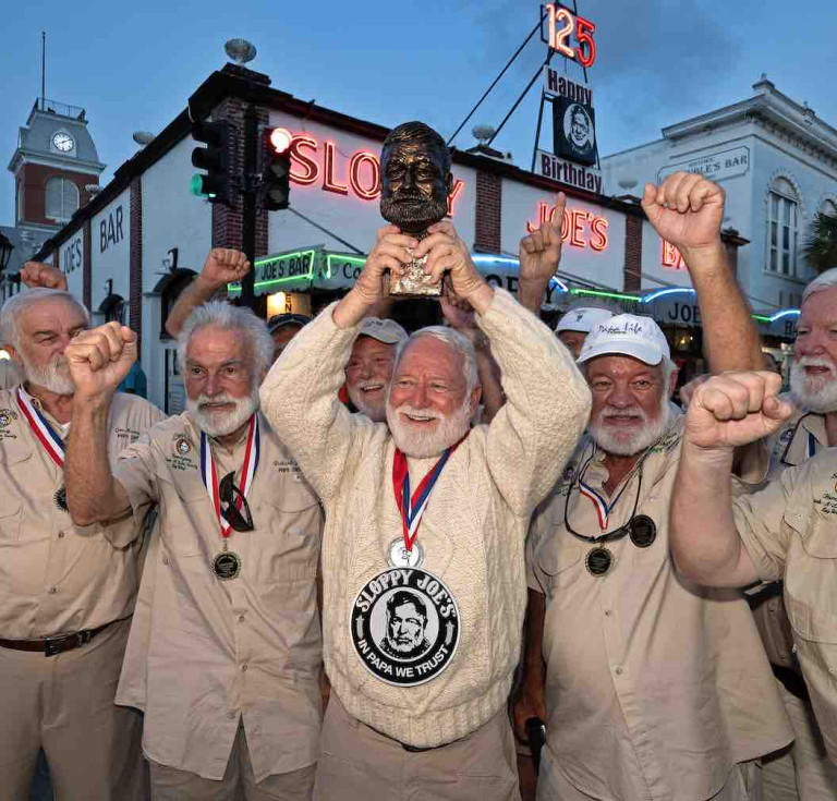 On his tenth attempt, David 'Bat' Masterson celebrates his 2024 victory with past winners of the Hemingway Look-Alike Contest outside Sloppy Joe's Bar in Key West.